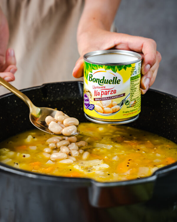 Dodawanie białej fasoli Bonduelle do gotującej się zupy jesiennej